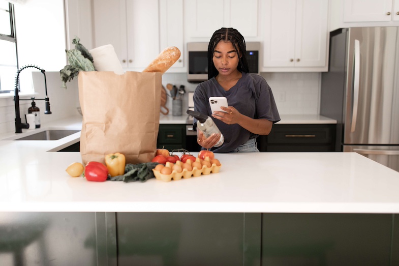 Woman photographing products at home for Field Agent's new product trial feedback.