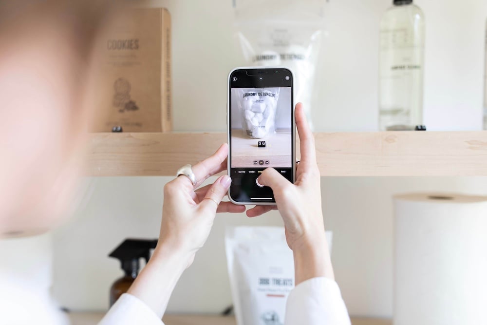 Woman photographing a product on a store shelf for concept testing